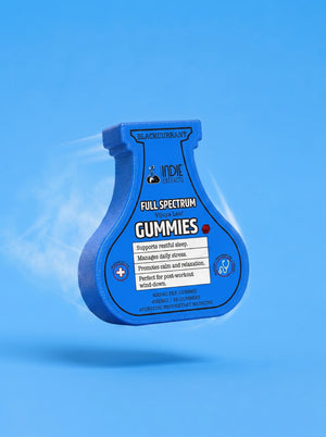 A blue squeeze bottle of YDIE Gummies floating against a solid blue background, with white gummy smoke effects on the left side.