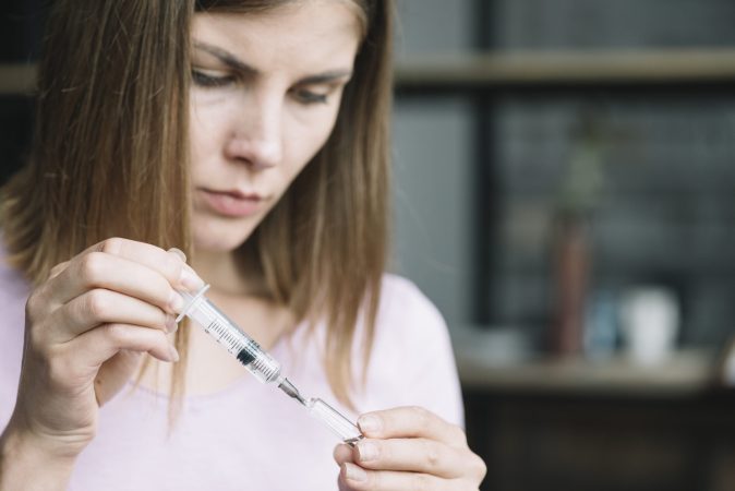 woman-s-hand-filling-syringe-with-medicine